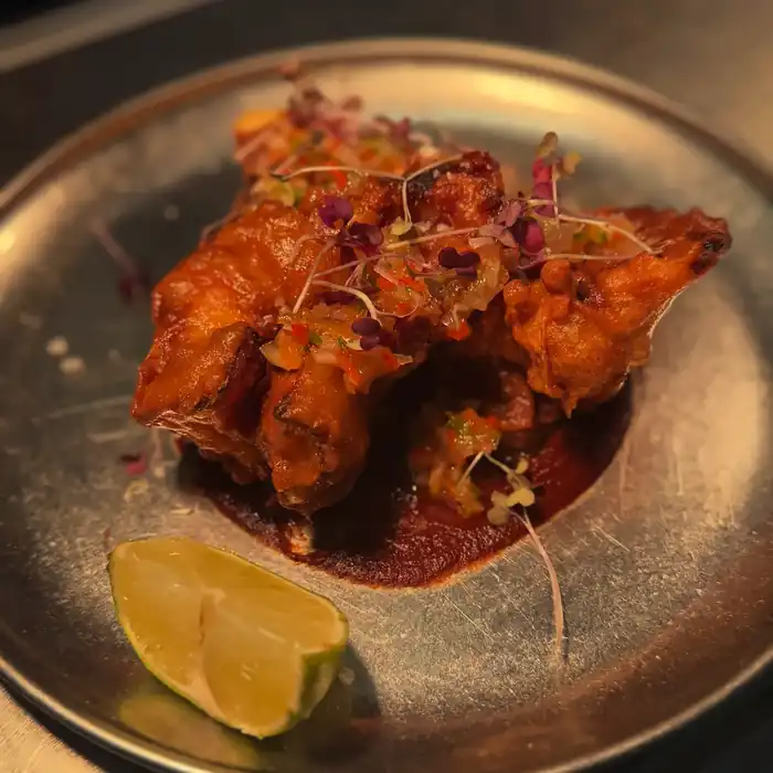 Orejita de cochinillo frita con mole y lima