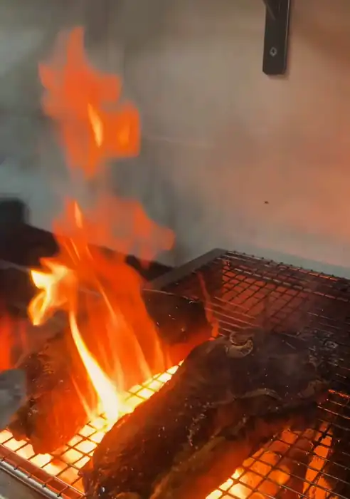 Carne en la parrilla entre llamas